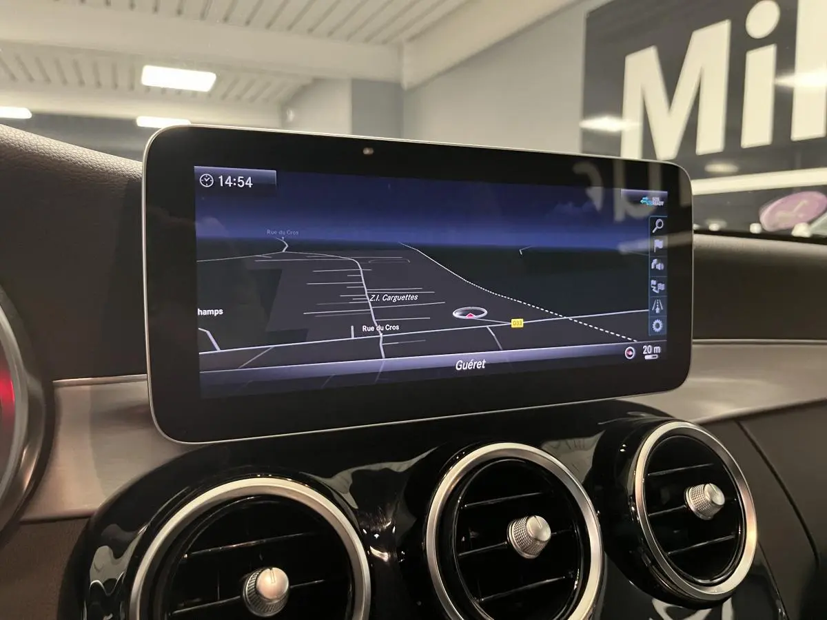 Écran de navigation couleur affichant une carte dans l'habitacle d'une Mercedes Classe C Break blanc.