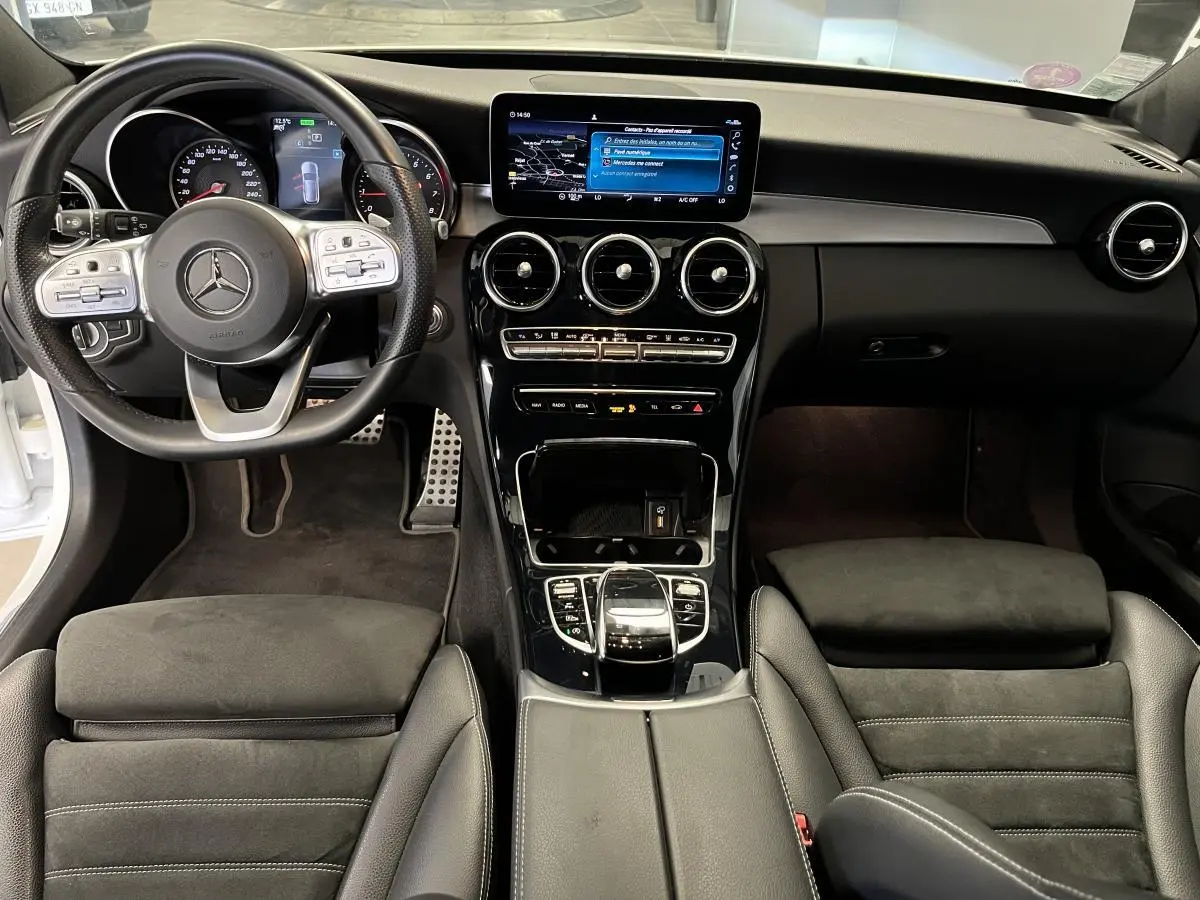 Vue intérieure avant de la Mercedes Classe C Break 300 e AMG Line, tableau de bord noir avec écran central tactile.