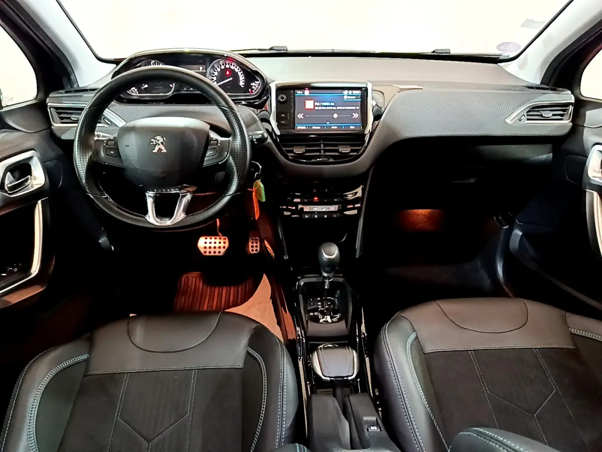 Intérieur Peugeot 2008 gris foncé vu de face, volant cuir multifonctions et écran tactile central lumineux.