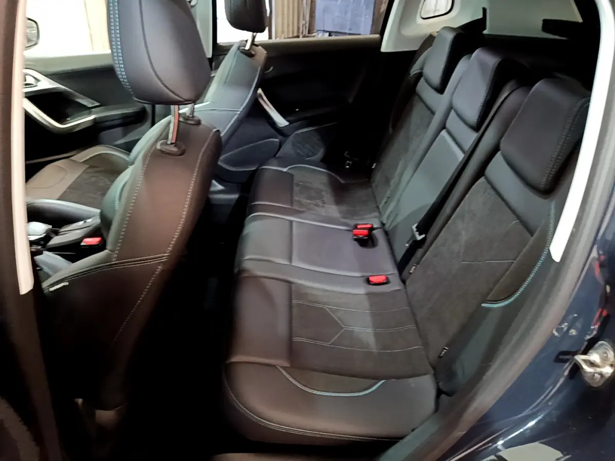Vue intérieure côté droit montrant la banquette arrière en cuir noir et tissu gris du Peugeot 2008 gris foncé de 2019.
