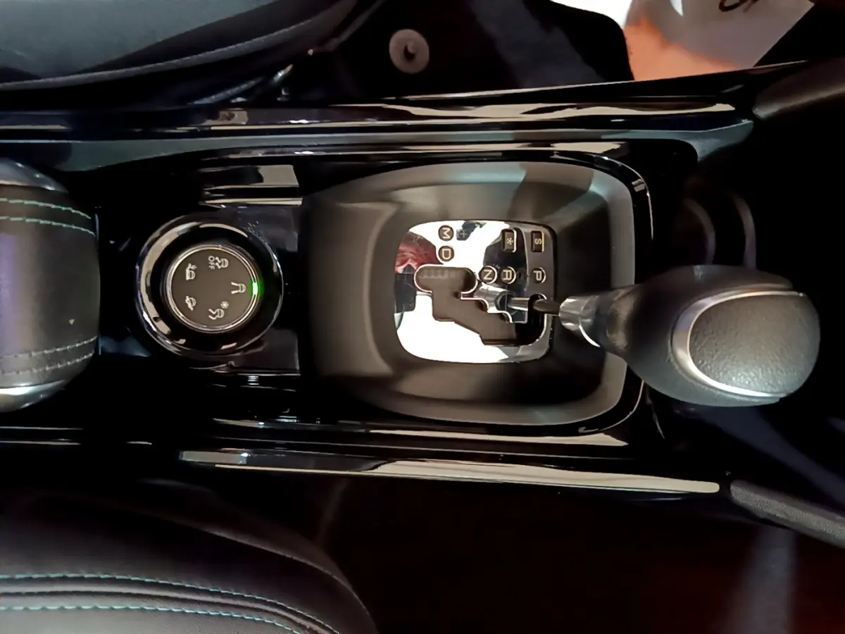 Gros plan sur la commande de boîte automatique et le sélecteur de modes de conduite du Peugeot 2008 gris foncé, intérieur noir.