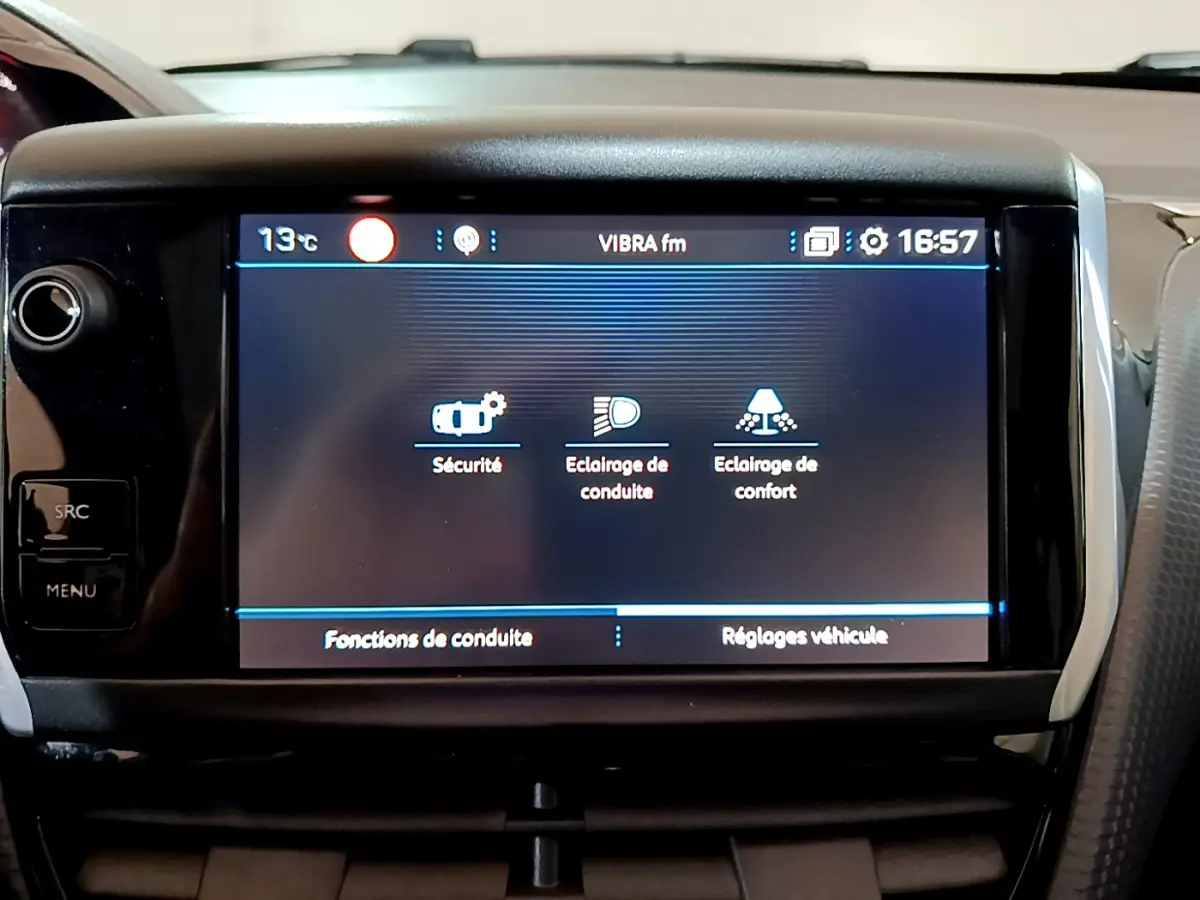 Écran tactile central du tableau de bord du Peugeot 2008 2019 affichant les réglages de sécurité et d’éclairage.