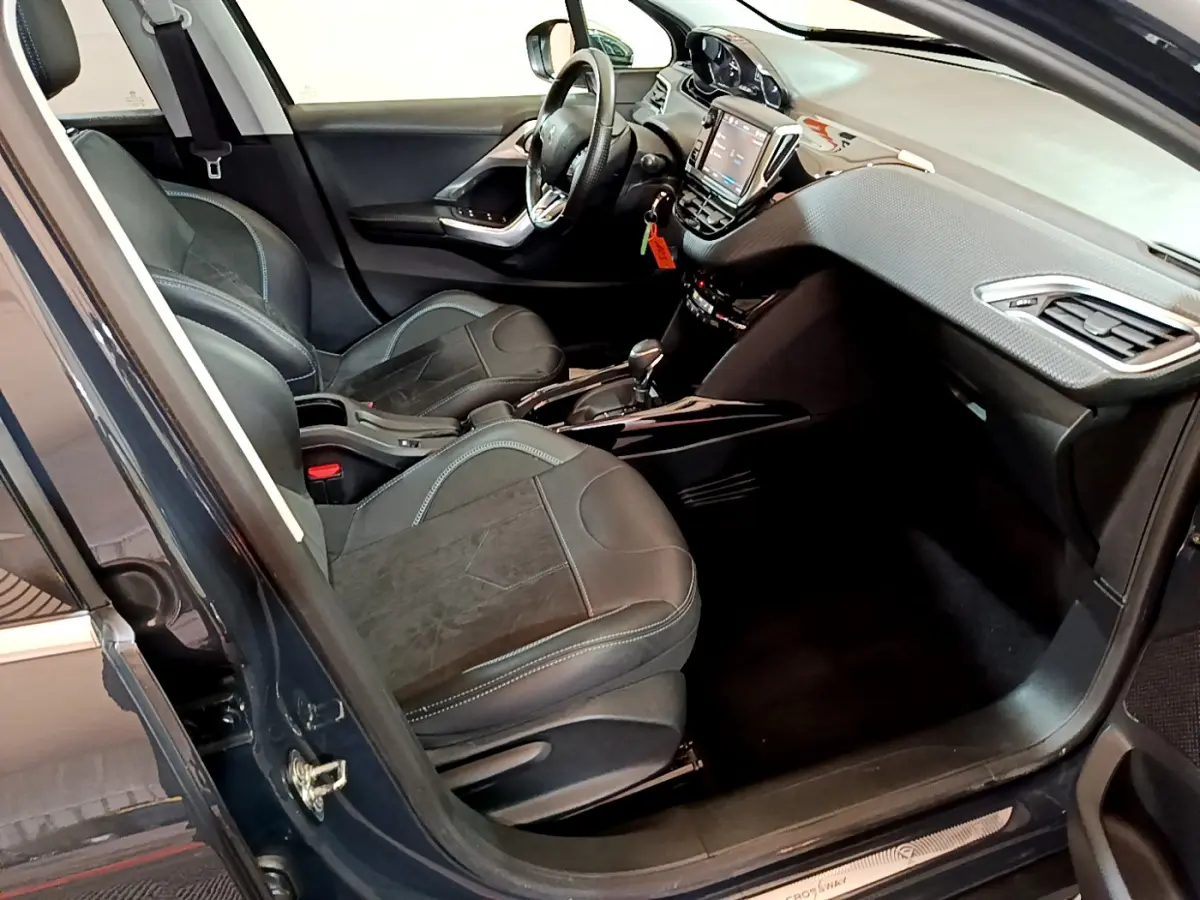 Intérieur avant droit du Peugeot 2008 gris foncé, avec sièges cuir et tableau de bord tactile visible.