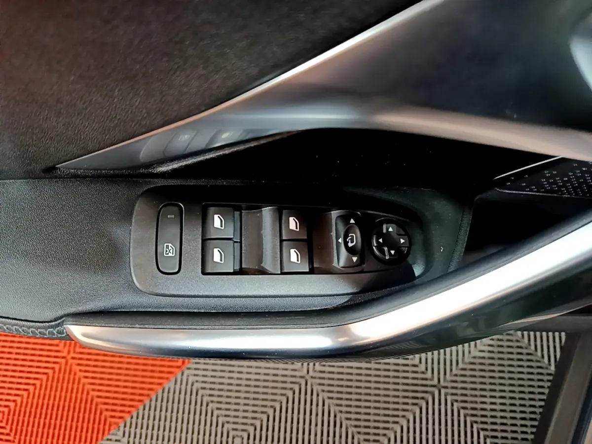 Commande des vitres électriques et réglage des rétroviseurs sur la porte côté gauche d’un Peugeot 2008 gris foncé.