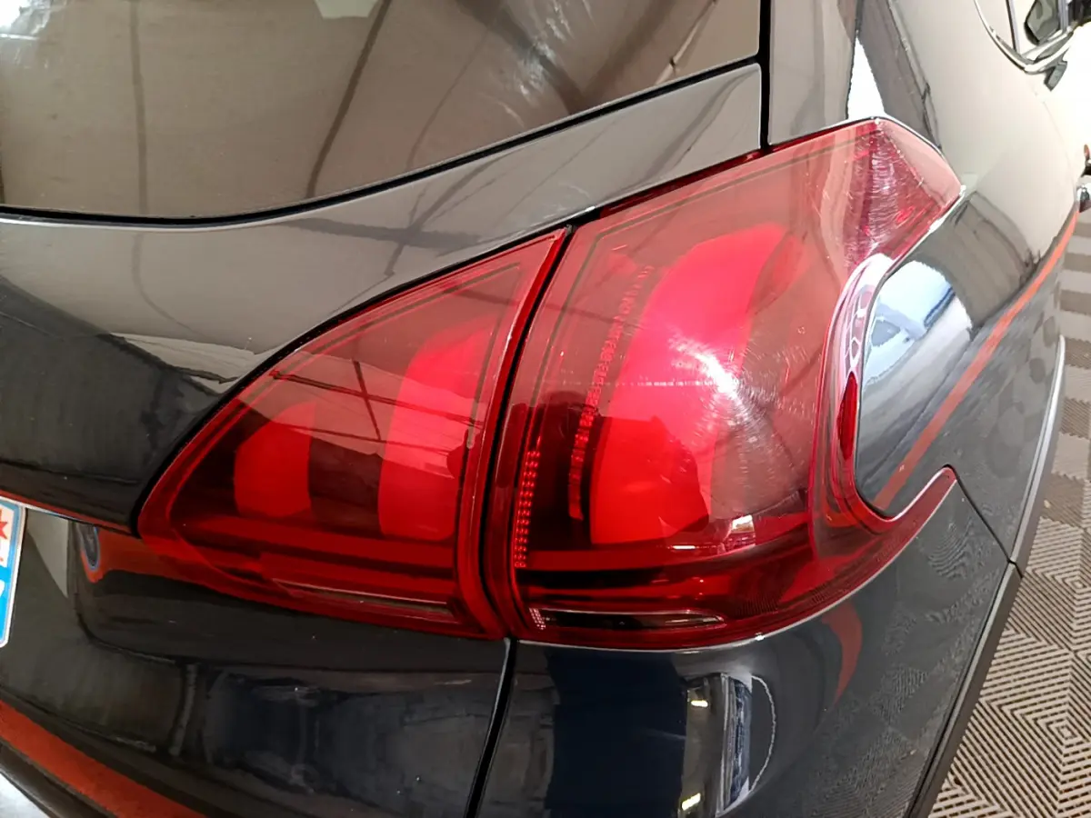Gros plan sur le feu arrière droit rouge d'un Peugeot 2008 gris foncé, version Crossway 2019.