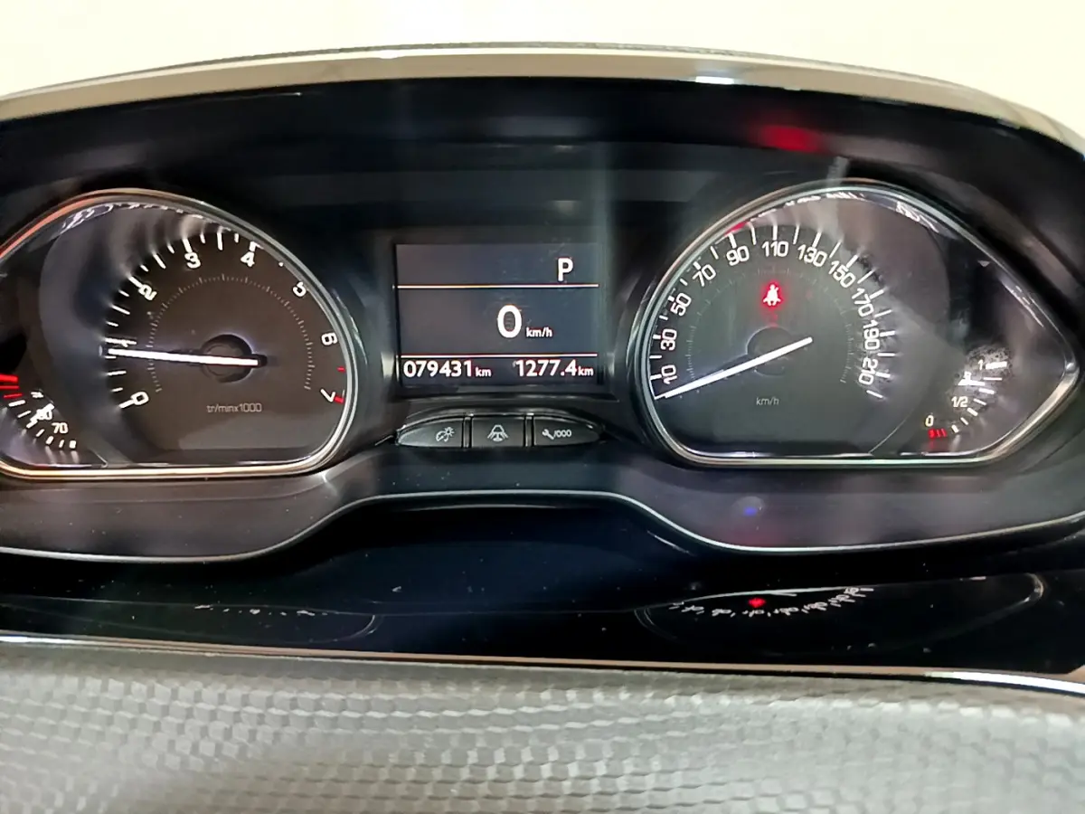 Tableau de bord du Peugeot 2008 gris foncé, affichage digital au centre avec compteur vitesse et compte-tours analogiques.