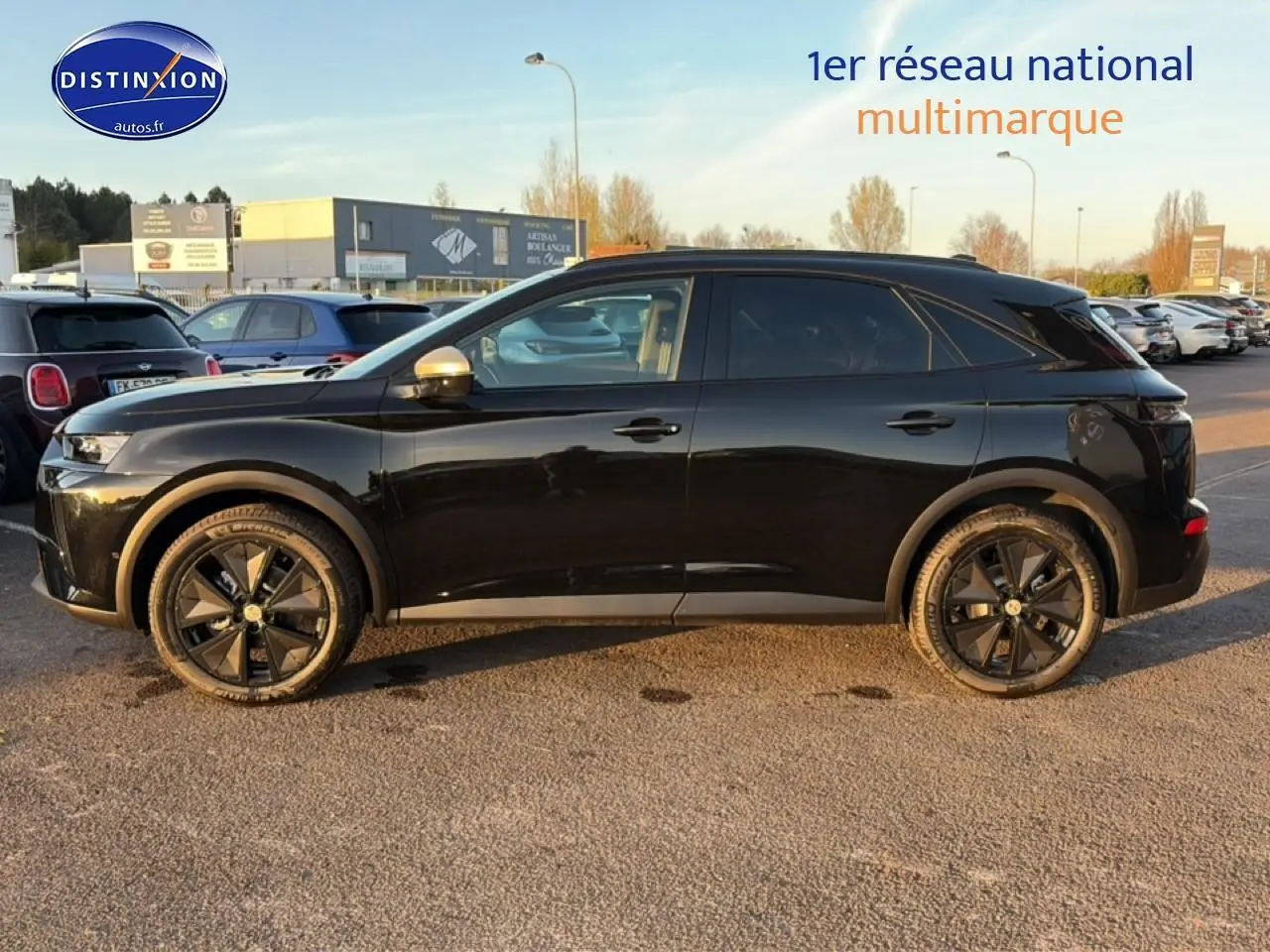 Vue de profil côté gauche d’un DS7 noir 2026 avec jantes noires et vitres arrière surteintées, stationné en extérieur.