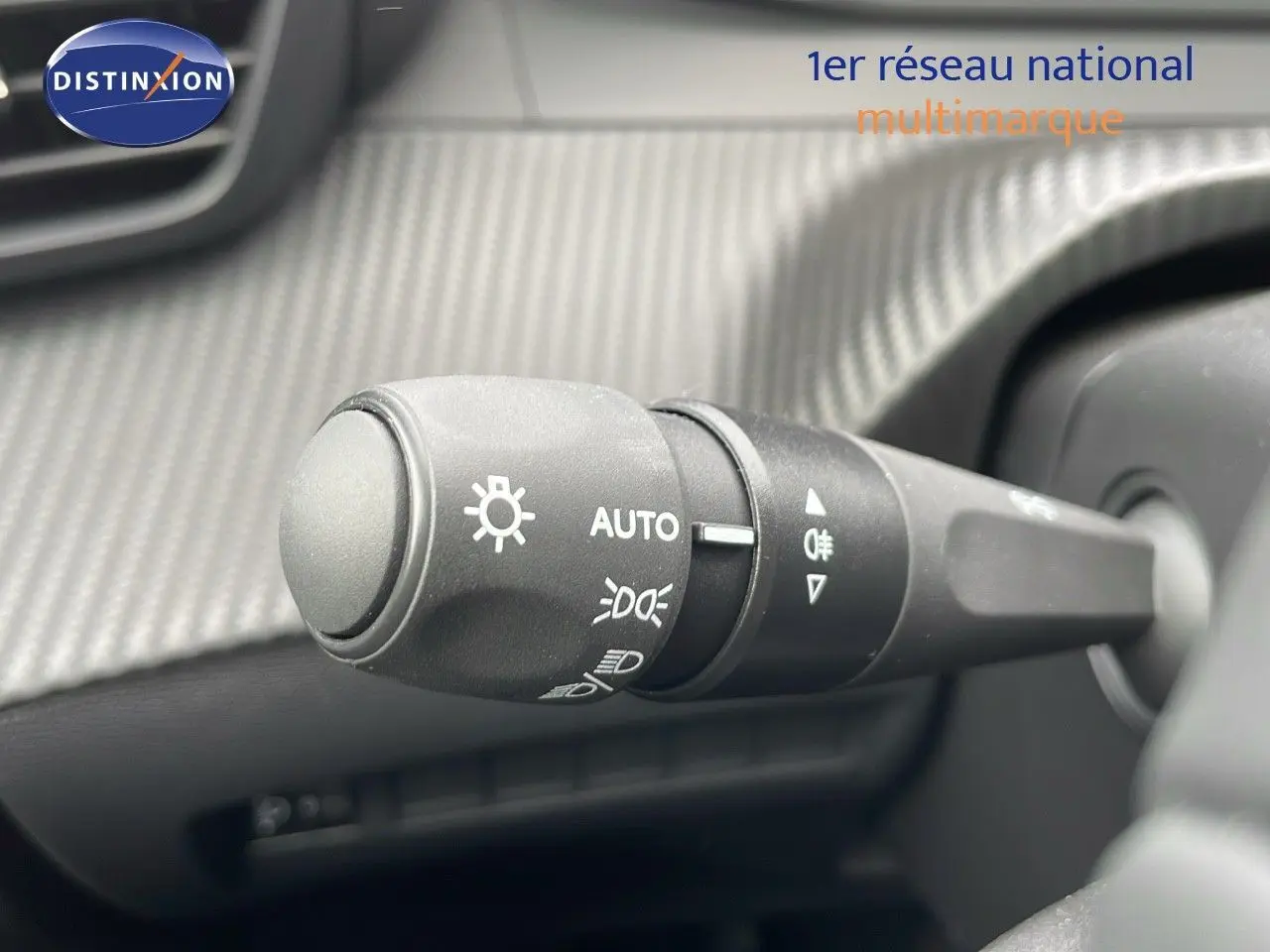 Gros plan sur la commande d'éclairage du tableau de bord d'une Peugeot 208 noire Perla Metal 2024.