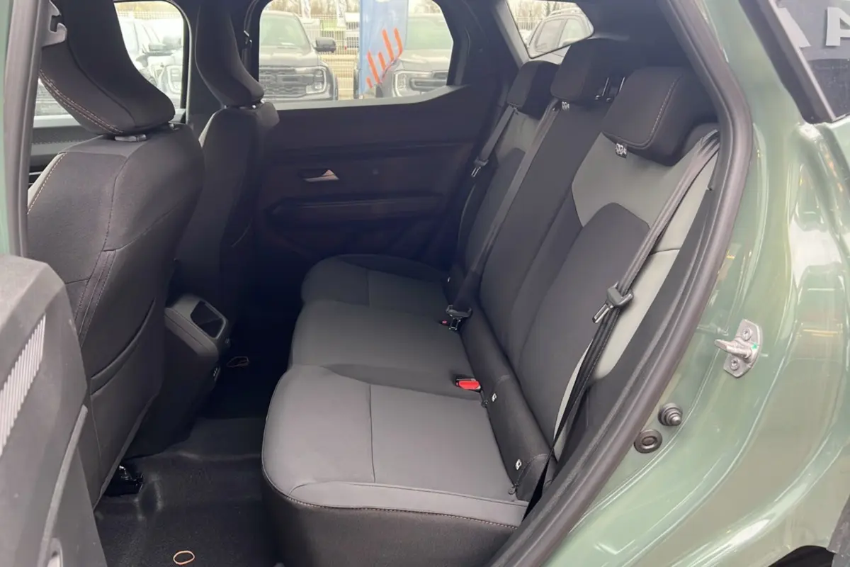 Vue côté gauche de l'habitacle arrière du Dacia Duster 2025 kaki lichen avec banquette noire et ceintures visibles