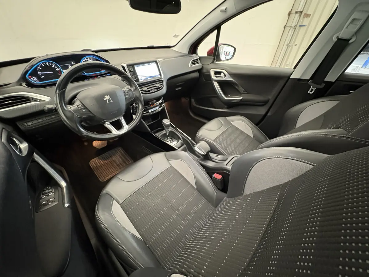 Intérieur noir du Peugeot 2008 2019, vue côté conducteur, volant cuir et écran tactile central visible.