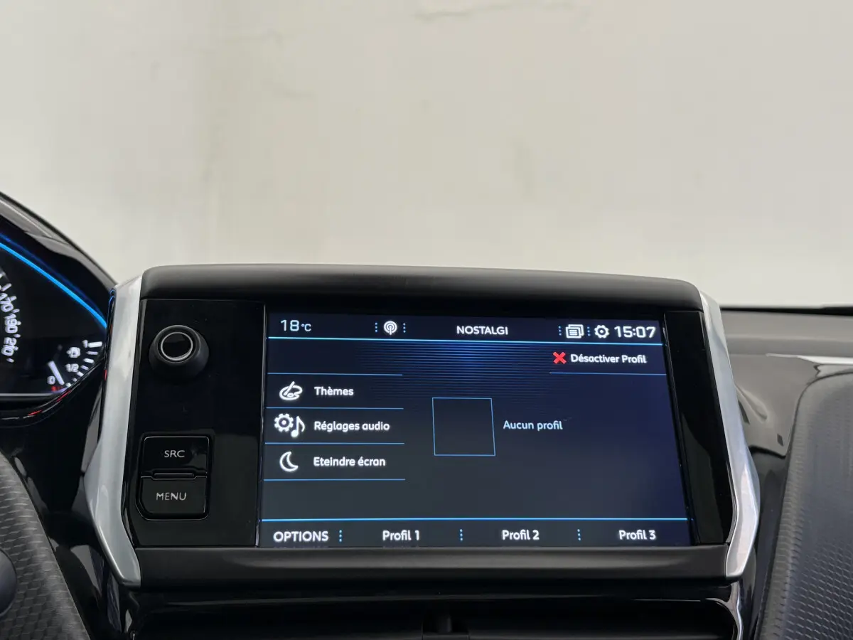 Écran tactile central de 7 pouces du tableau de bord du Peugeot 2008 rouge, affichant le menu audio et profils utilisateur.
