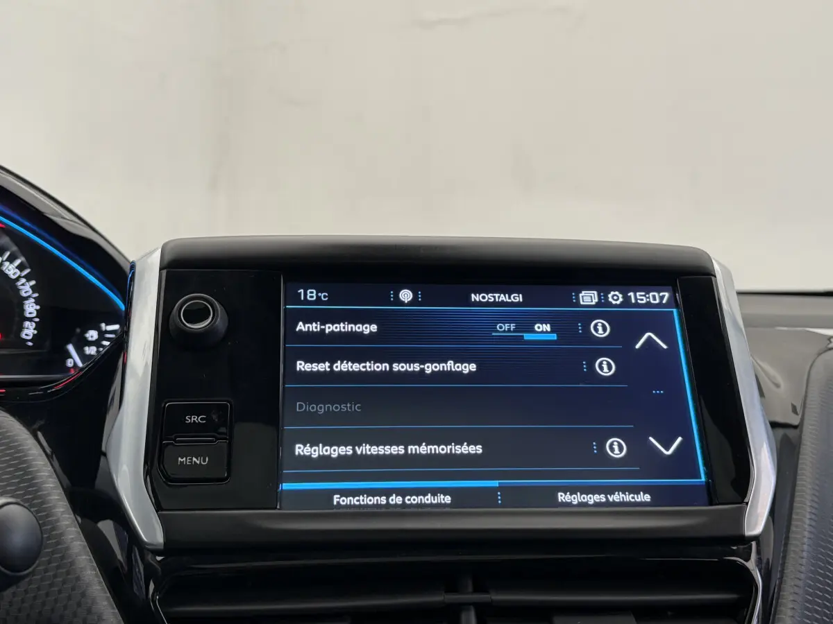 Écran tactile central du tableau de bord du Peugeot 2008 rouge, affichant les réglages d’aide à la conduite.