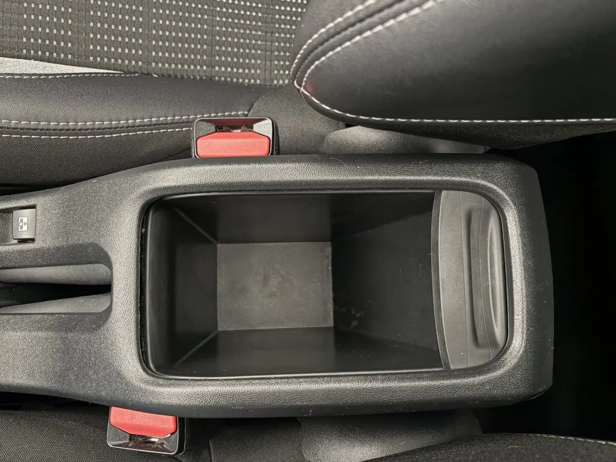 Vue plongeante sur le rangement central noir entre les sièges avant du Peugeot 2008 rouge Puretech 2019