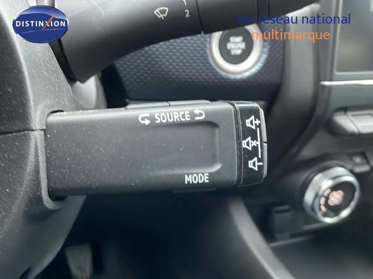 Gros plan sur la commande au volant "Source" et "Mode" du tableau de bord intérieur d'une Renault Arkana 2025.