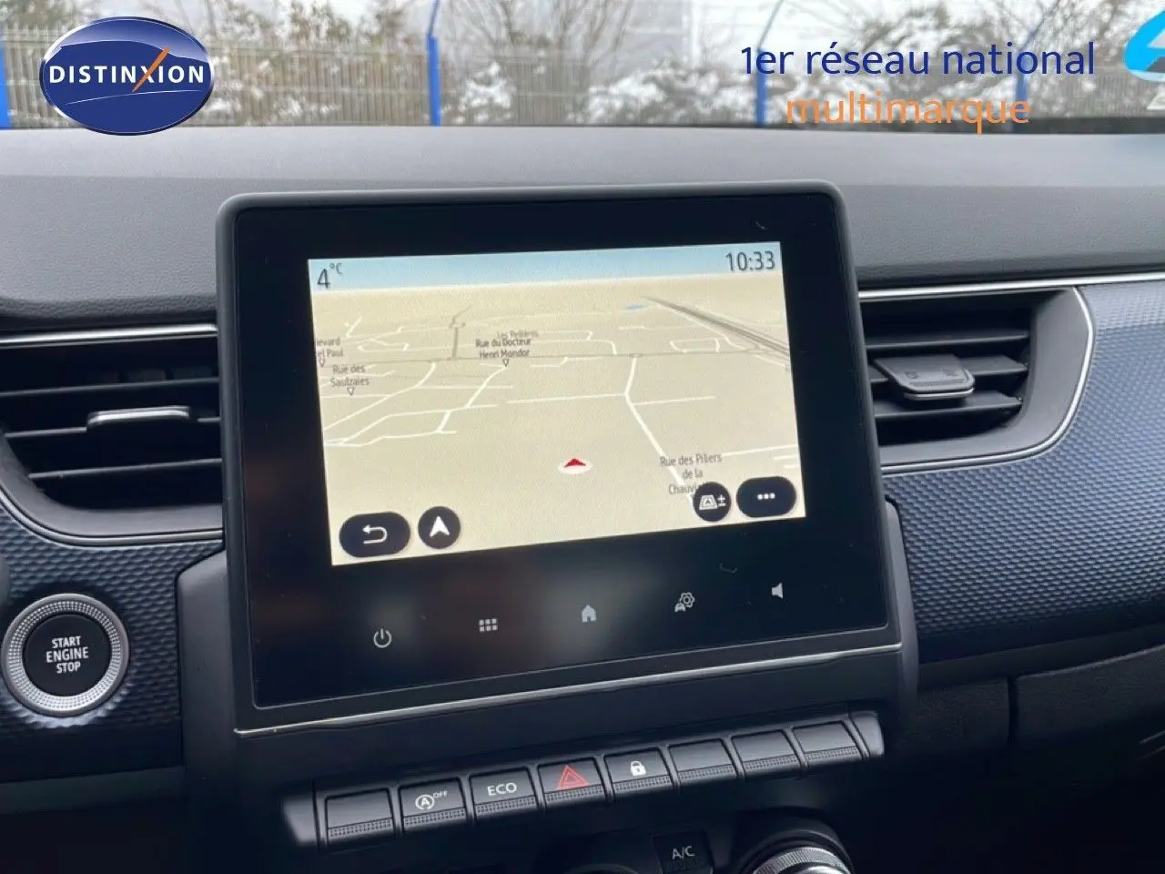 Tablette tactile du système de navigation au centre du tableau de bord de la Renault Arkana 2025, avec bouton Start Engine à gauche.
