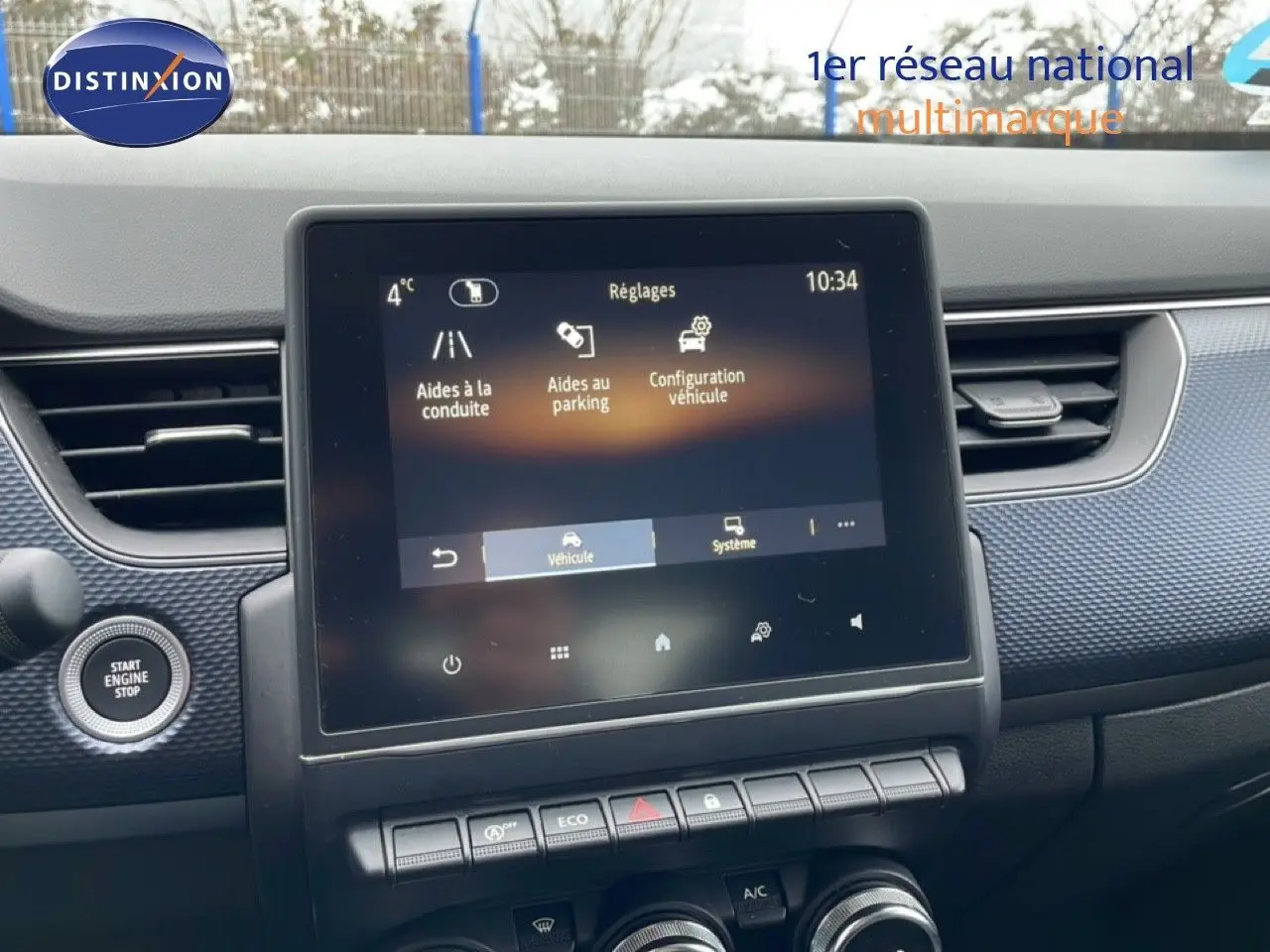 Vue intérieure centrée sur l'écran tactile et la console centrale du Renault Arkana bleu Zanzibar 2025.