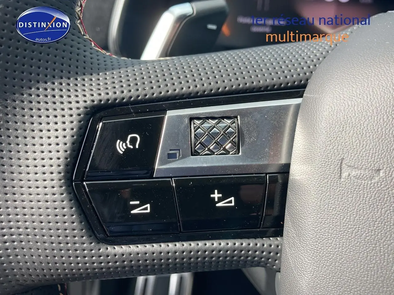 Gros plan sur les commandes vocales et volume au volant cuir perforé du DS7 Crystal Pearl 2026.