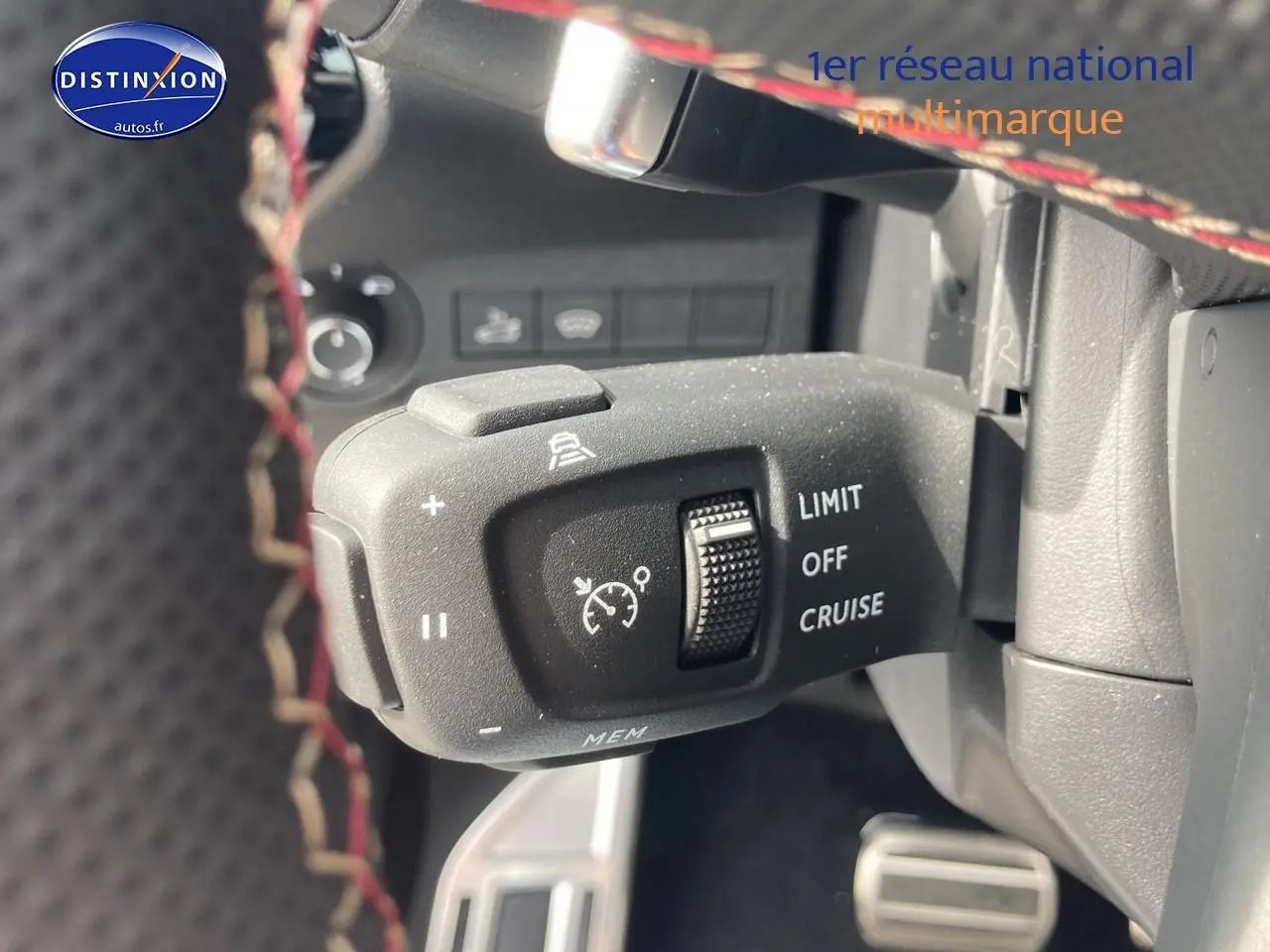 Gros plan sur la commande de régulateur de vitesse du DS7 1.5 BlueHDi 130 Performance Line, intérieur noir avec surpiqûres rouges.