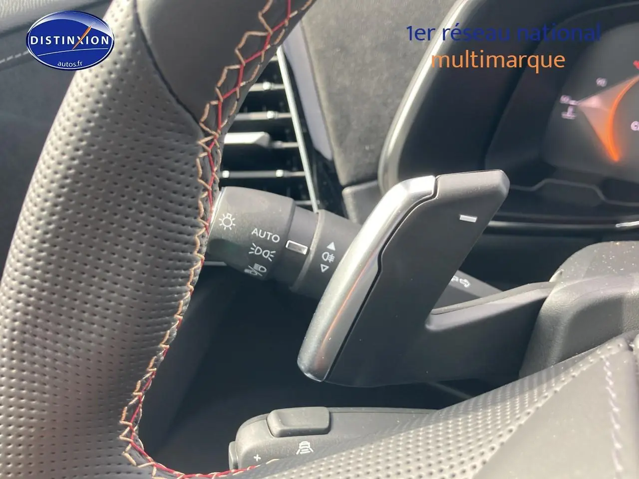 Gros plan sur la palette de changement de vitesses au volant de la DS7 Crystal pearl, intérieur noir avec surpiqûres rouges.