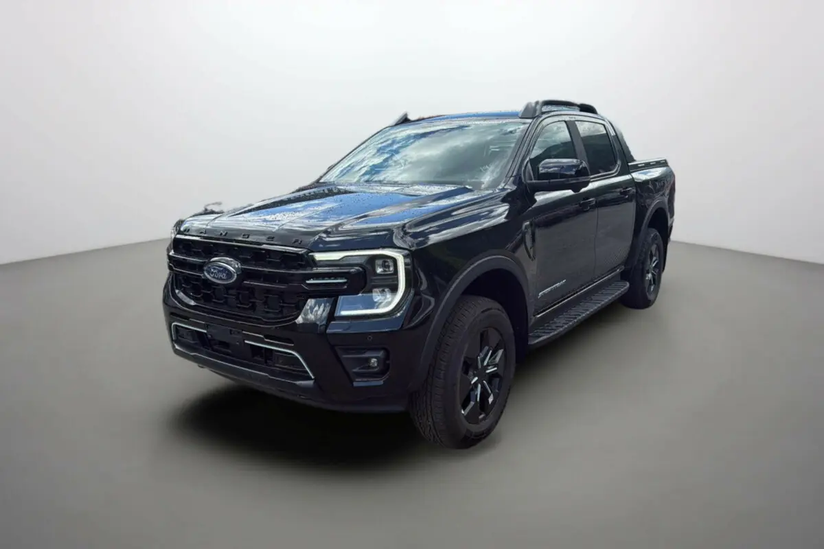 Ford Ranger 2.3 PHEV noir agate en 3/4 avant droit, avec barres de toit et jantes alu noires.