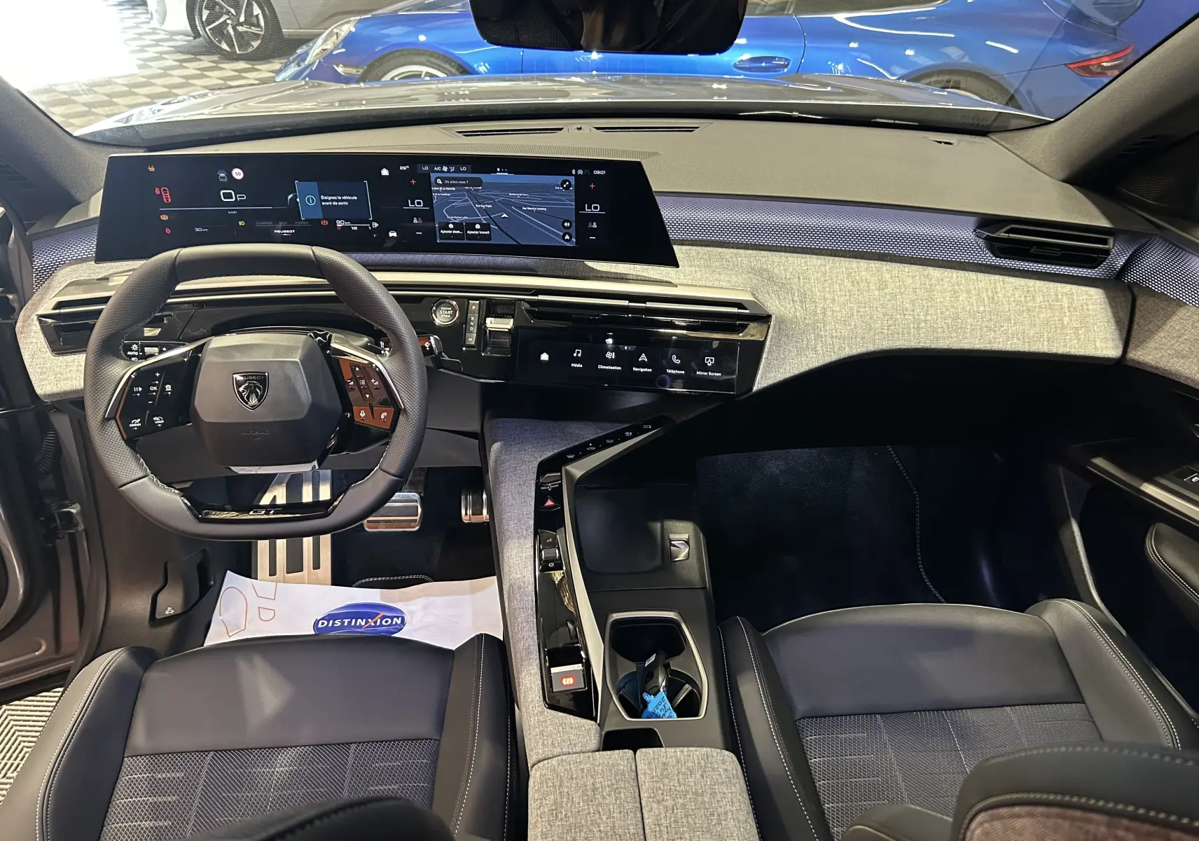 Vue intérieure avant du Peugeot 3008 gris Artense 2026, avec tableau de bord numérique large et volant compact multifonctions.