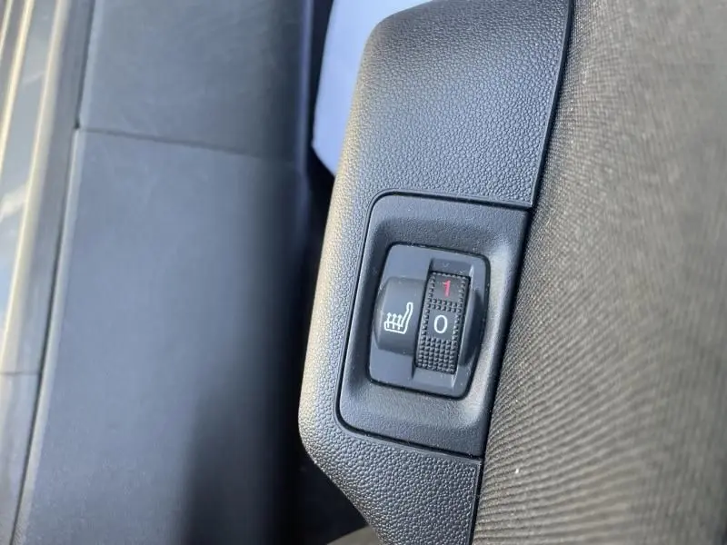 Gros plan sur le bouton de réglage du siège chauffant dans une Citroën C3 2019 gris foncé métal, version Feel.