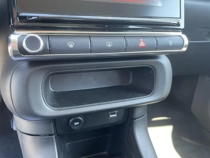 Détail de la console centrale de la Citroën C3 2019 gris foncé, avec boutons de désembuage et prise 12V visible.