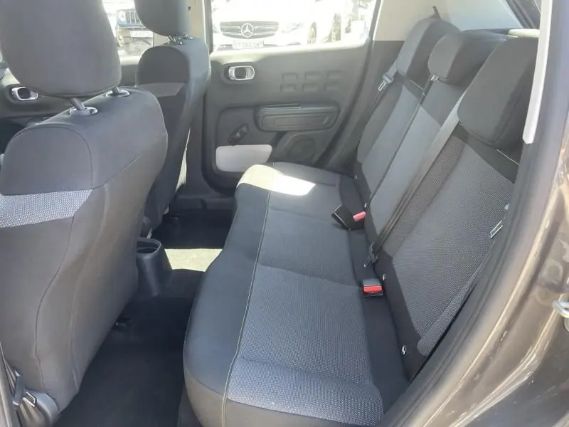 Vue intérieure arrière côté droit de la Citroën C3 82 CV Feel 2019, sièges tissu gris et ceintures de sécurité visibles.