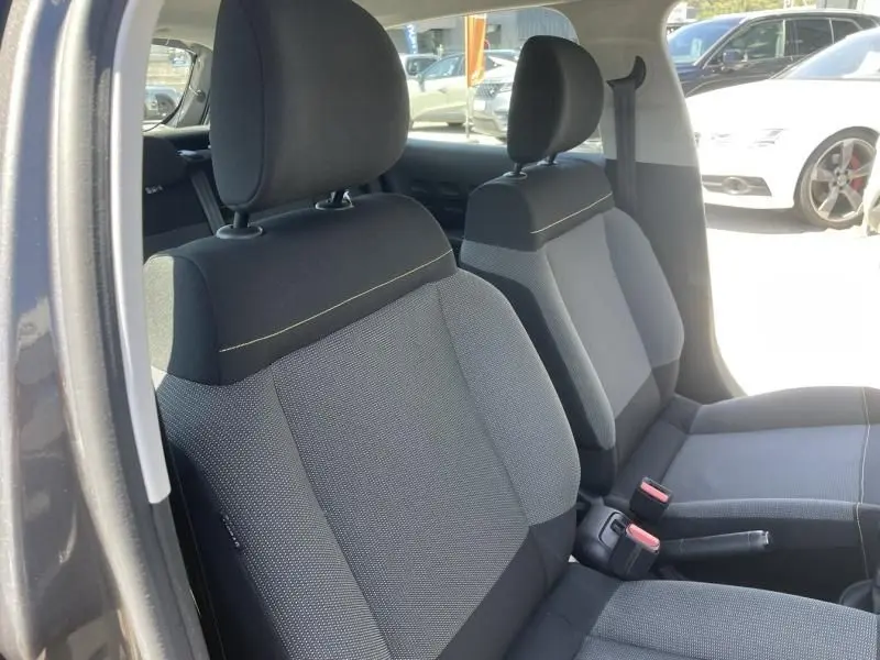 Vue intérieure des sièges avant en tissu gris et noir d'une Citroën C3 2019 gris foncé métal, version Feel 82 CV.