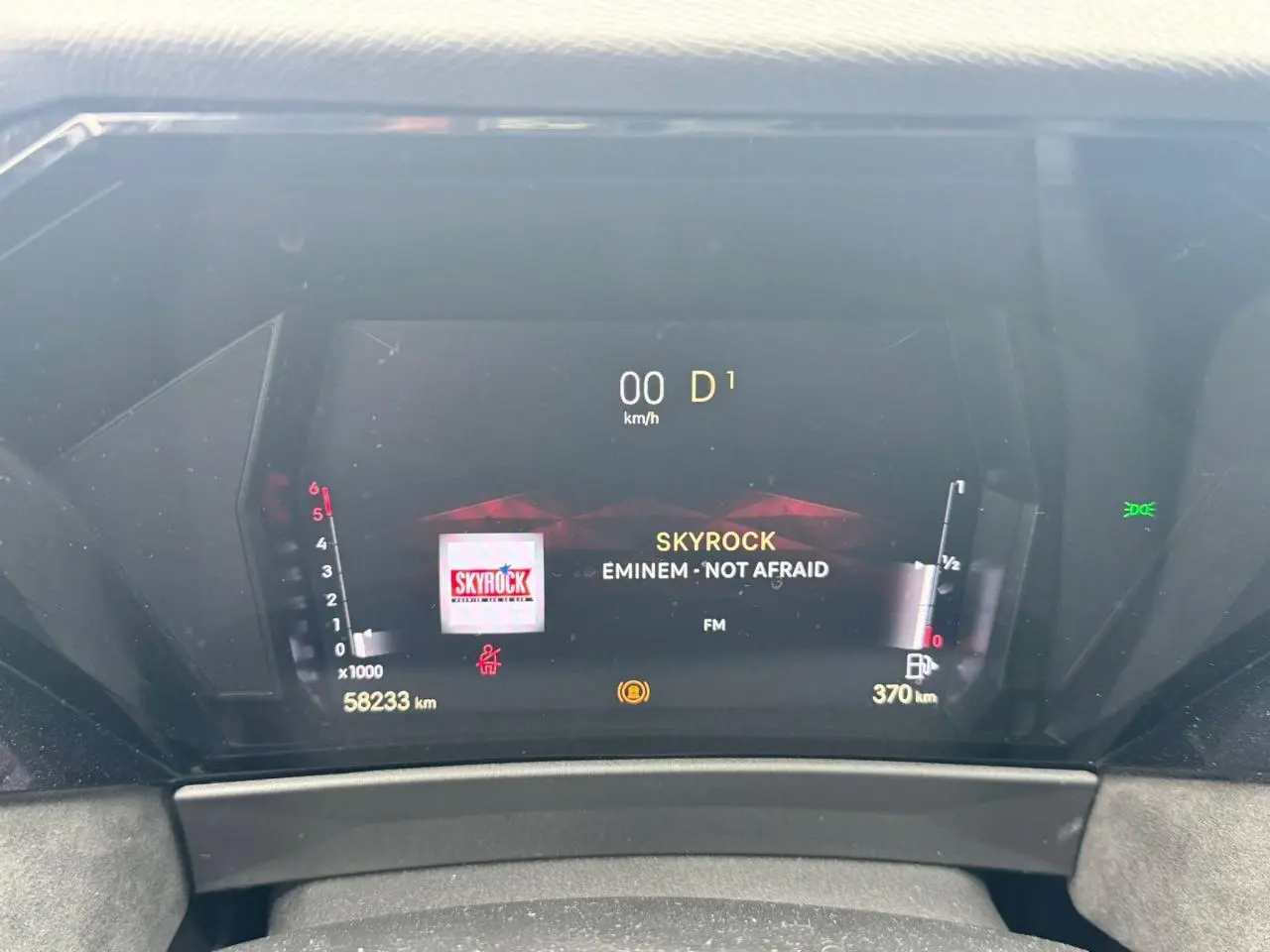 Tableau de bord numérique du DS4 rouge foncé, affichant la radio Skyrock et la vitesse à 0 km/h.