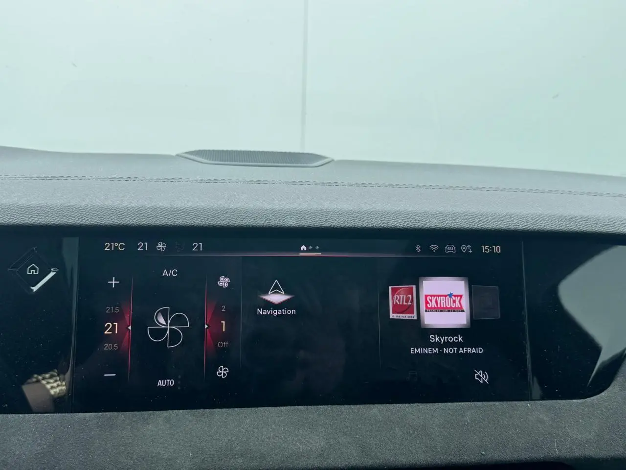 Tableau de bord numérique de DS4 Performance Line, affichant la climatisation et la radio Skyrock à l'avant.