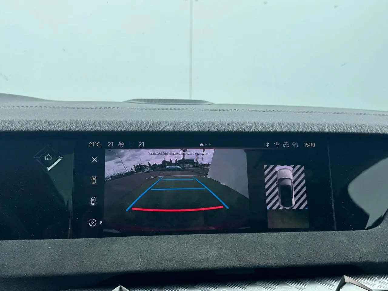 Écran central montrant la caméra de recul et la vue 360° d'une DS4 rouge foncé en stationnement.