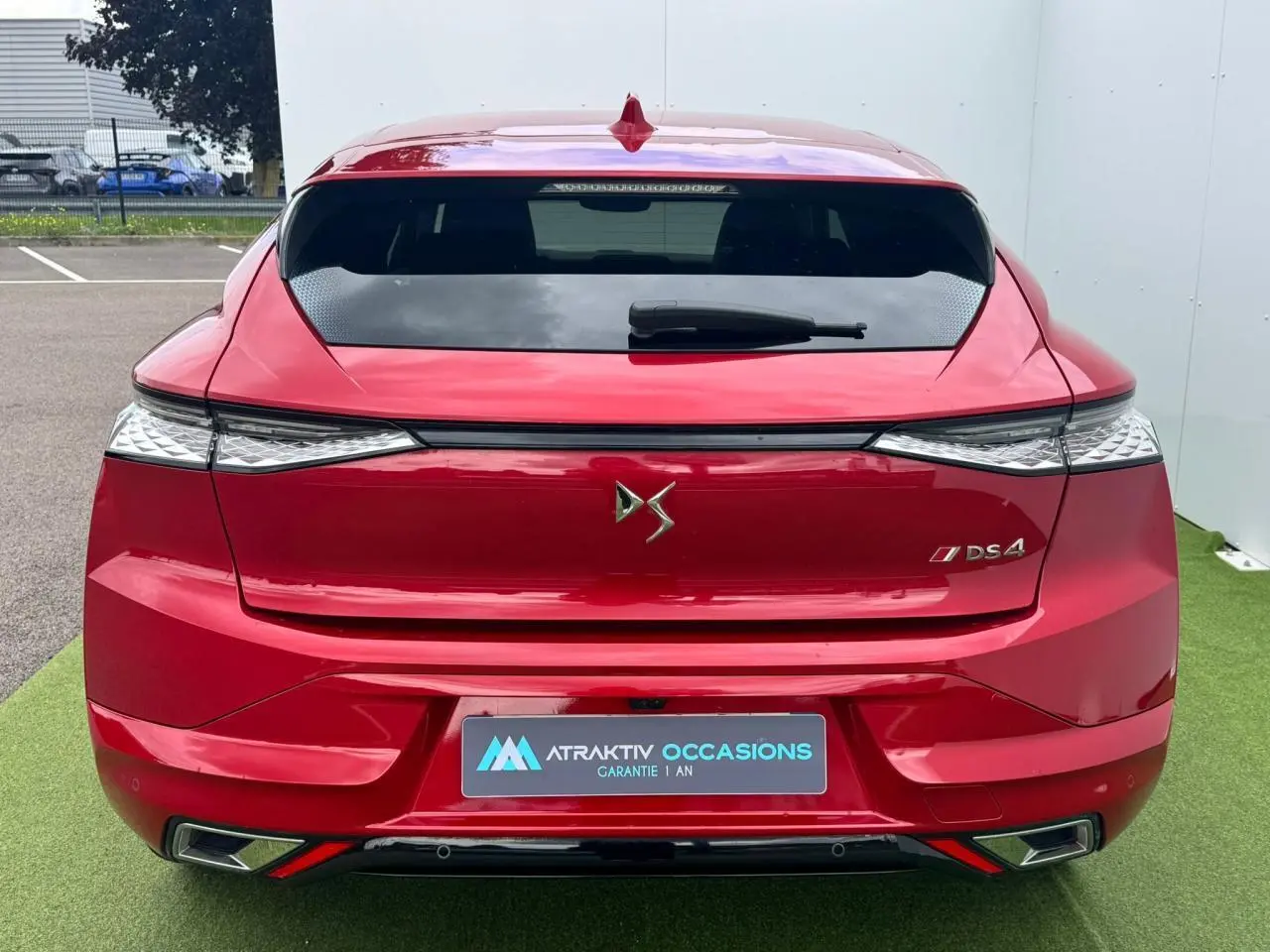 Vue arrière d'une DS4 rouge foncé avec feux arrière 3D et double sortie d'échappement chromée.