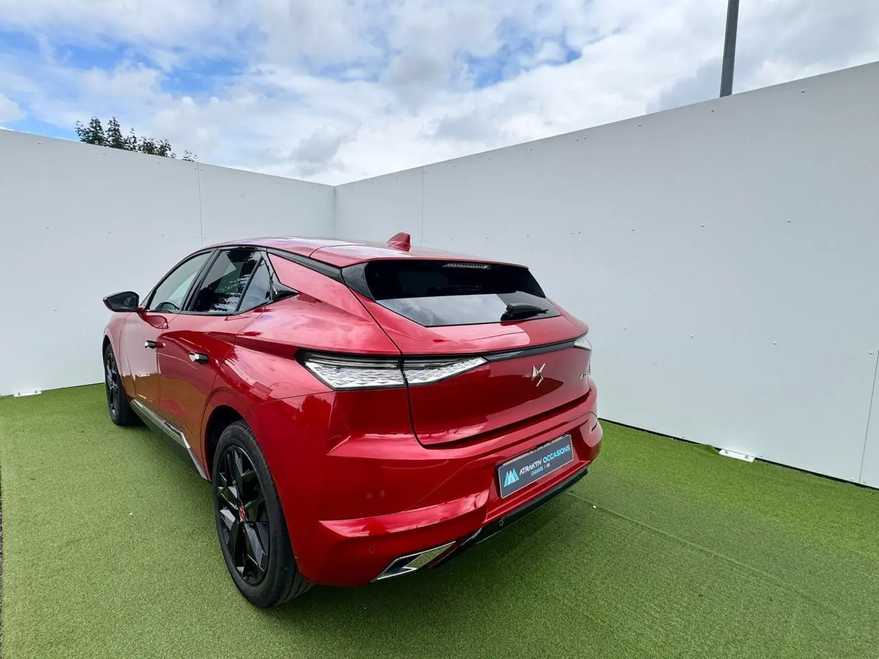 Vue 3/4 arrière droite d'une DS4 rouge foncé avec feux arrière LED et double sortie d'échappement chromée.