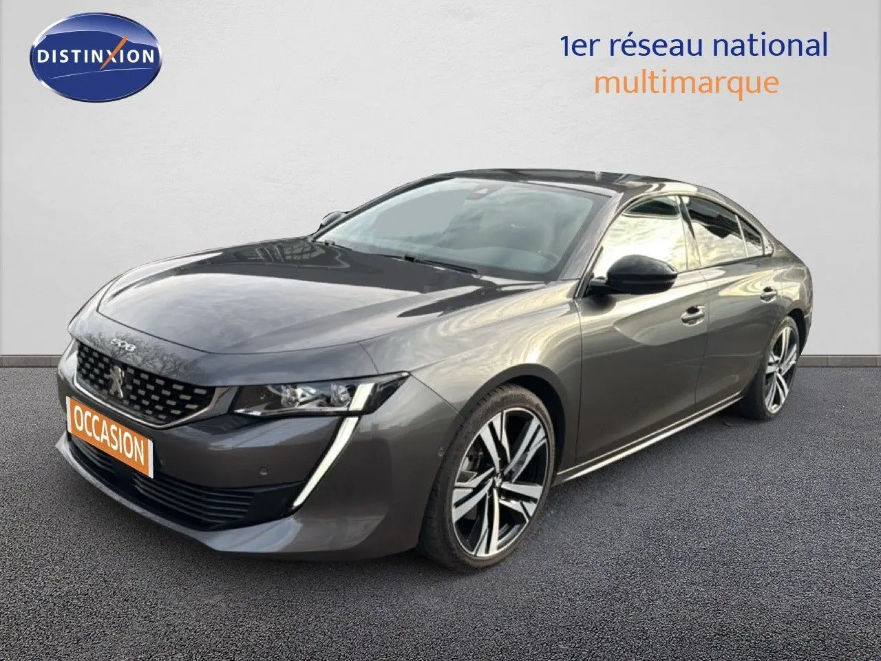 Peugeot 508 gris platinium en 3/4 avant droit, avec jantes alliage bicolores et feux LED distinctifs.