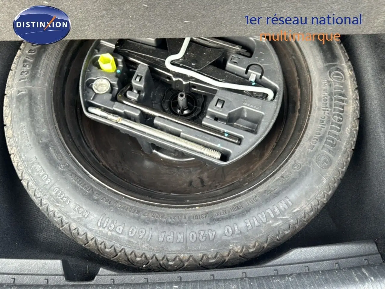 Gros plan sur la roue de secours avec outils intégrés dans le coffre d'une Peugeot 508 gris platinium.