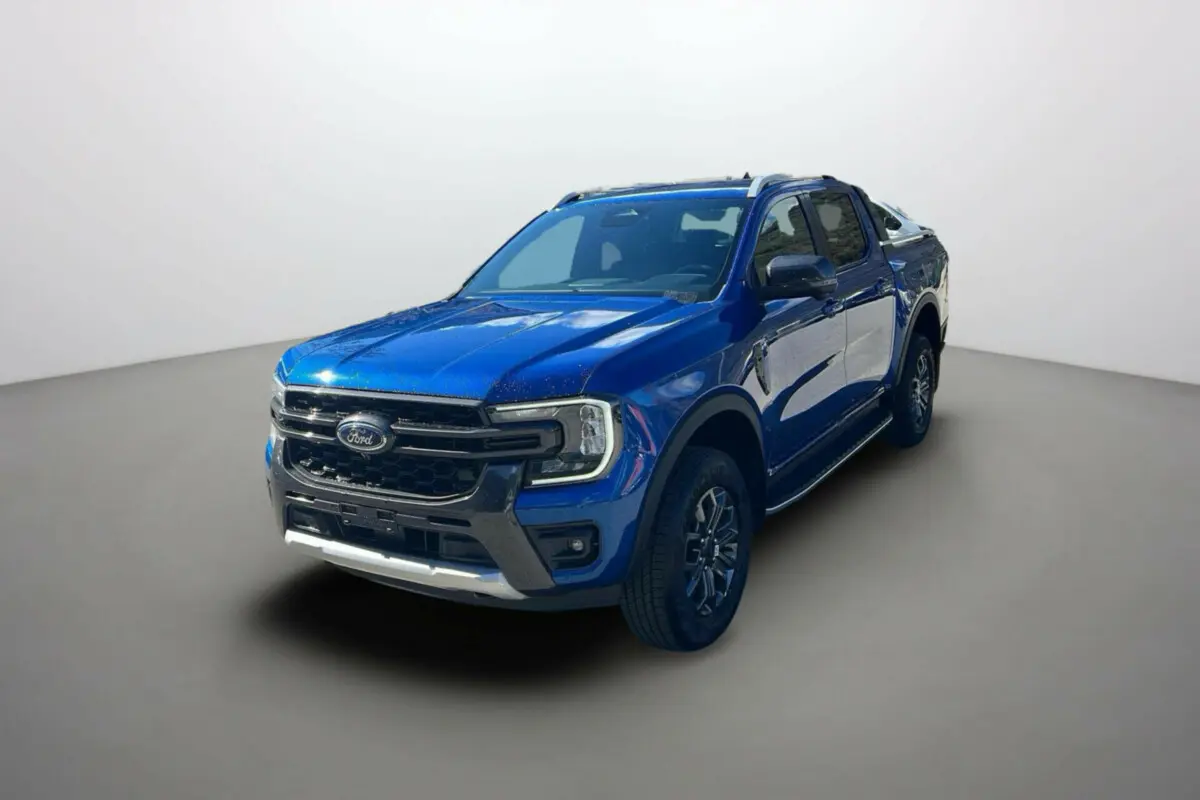 Ford Ranger 2.0 205 Wildtrak Plus bleu lightning en 3/4 avant avec barres de toit et jantes alu 18 pouces visibles