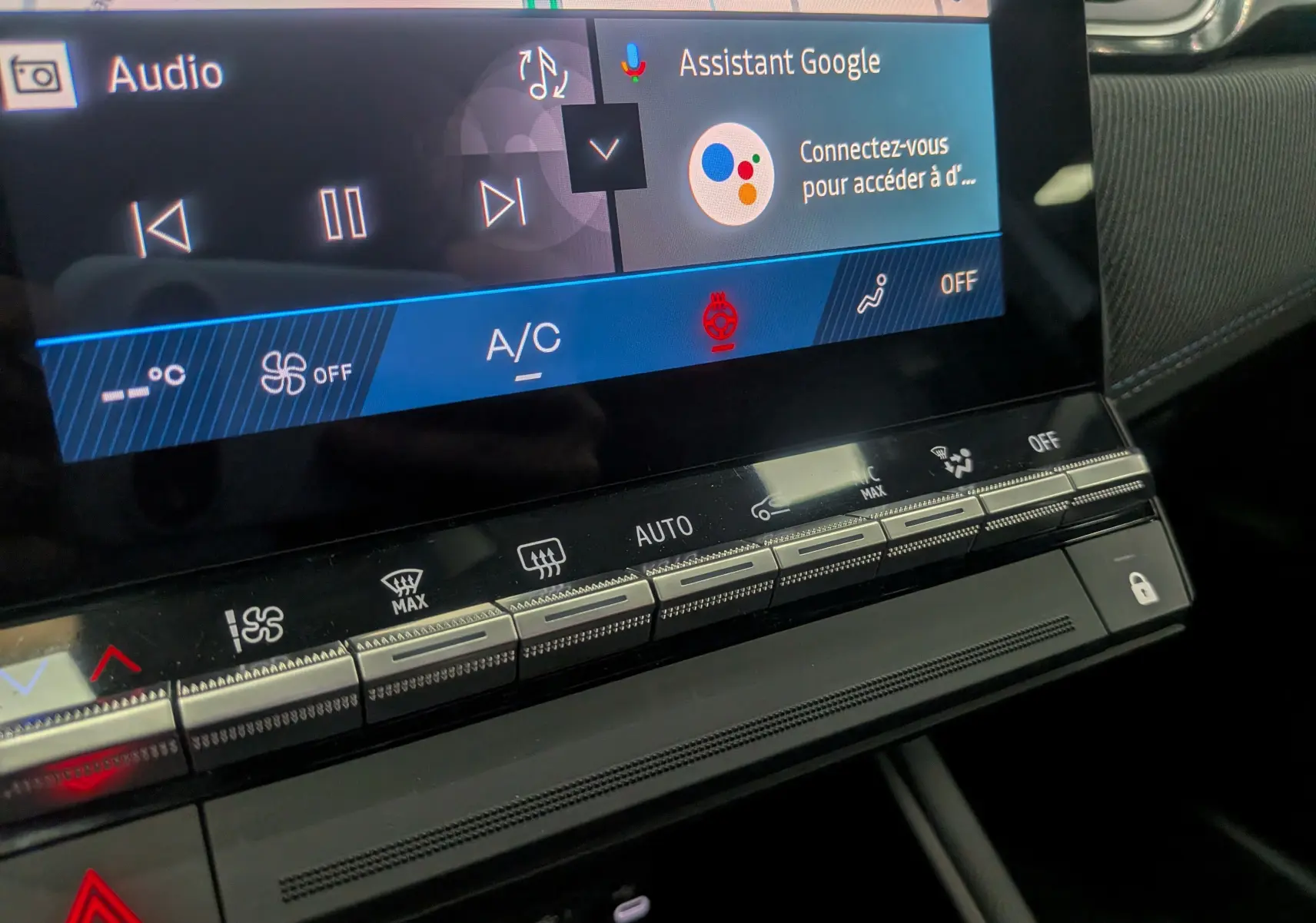Gros plan sur la console centrale tactile du Renault Symbioz gris Rafale, affichant les commandes climatisation et assistant Google.