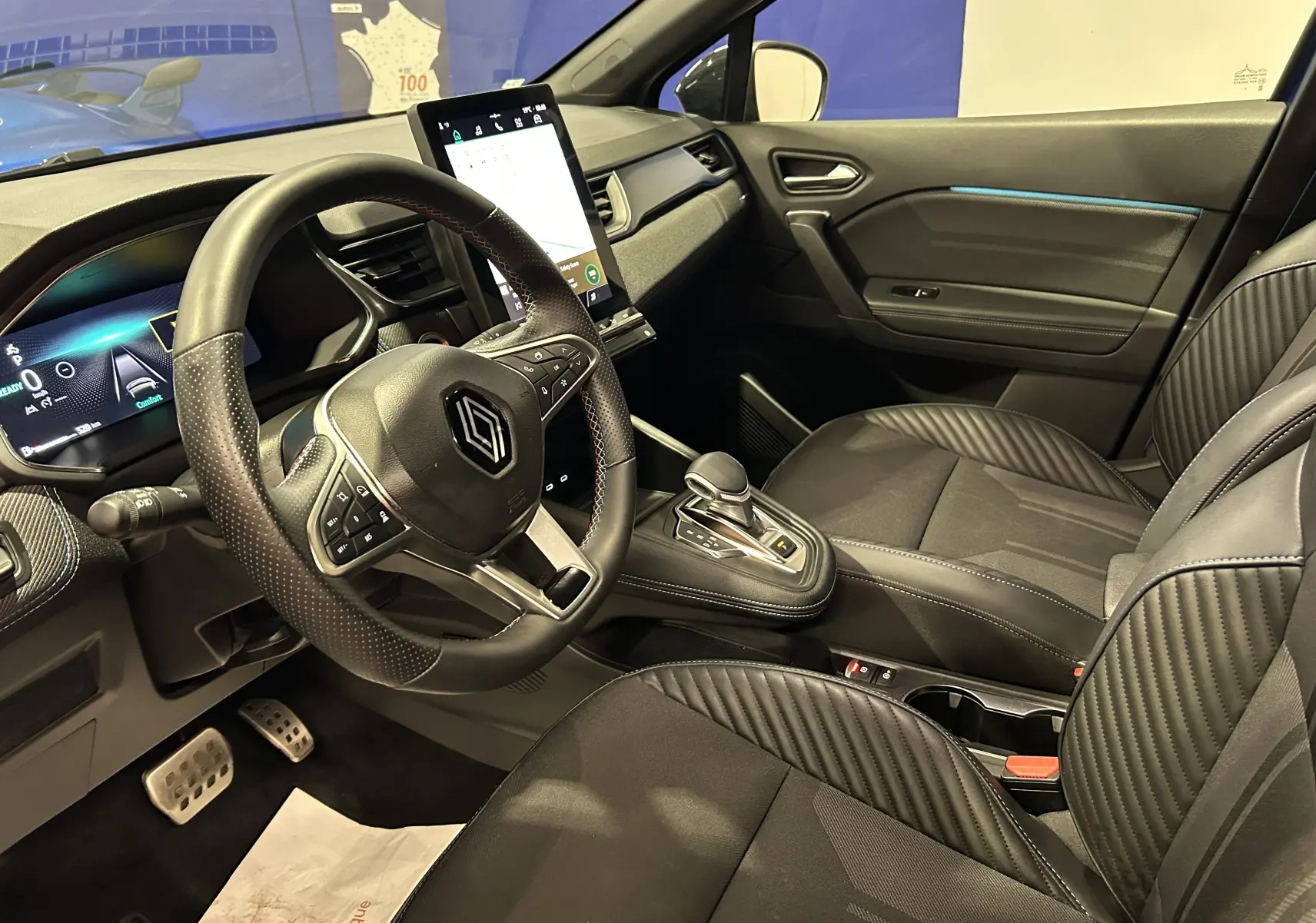 Vue intérieure côté conducteur du Renault Captur II Ph.2 avec volant multifonction, écran tactile vertical et sièges noirs.