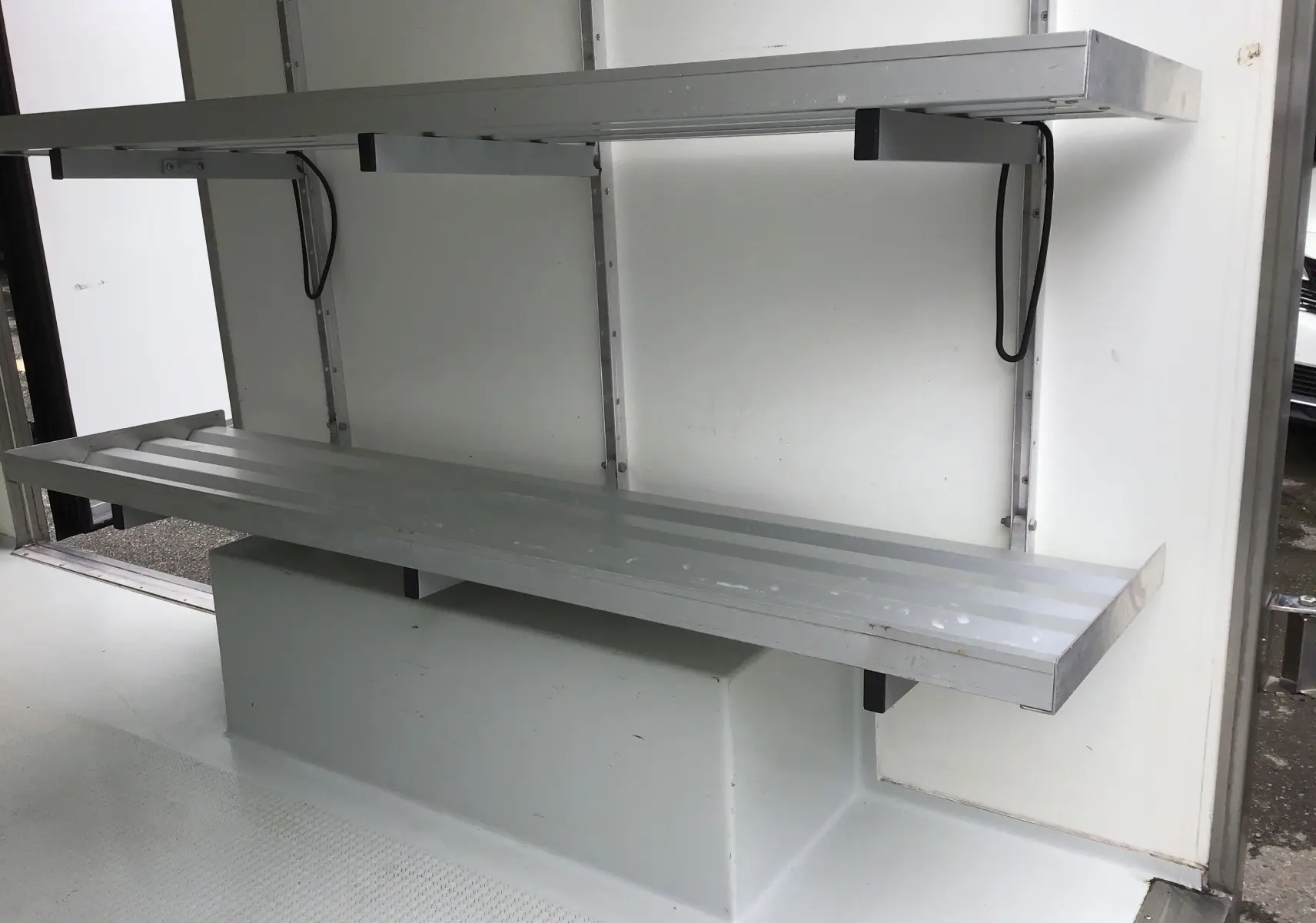 Intérieur blanc du Renault Trafic Plancher Cabine 2019 avec étagères métalliques dans la caisse frigorifique.