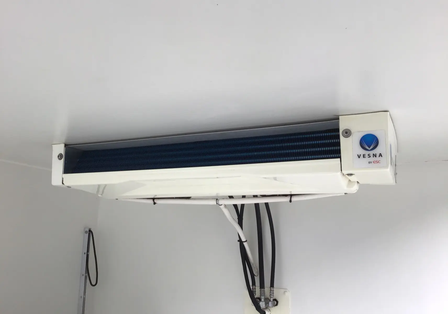 Gros plan sur le groupe frigorifique Vesna blanc fixé au plafond de la caisse frigorifique blanche du Renault Trafic Plancher Cabine.