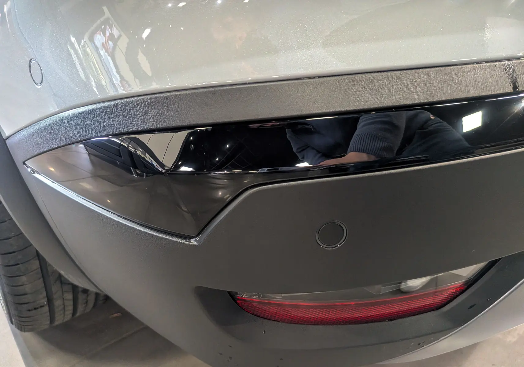 Détail du pare-chocs arrière gris Rafale du Renault Symbioz E-TECH avec insert noir brillant et feu rouge intégré.