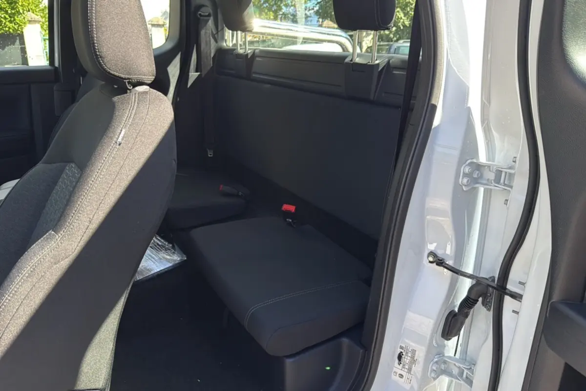 Vue intérieure côté droit du Ford Ranger blanc glacier 2025, montrant la banquette arrière compacte et la portière ouverte.