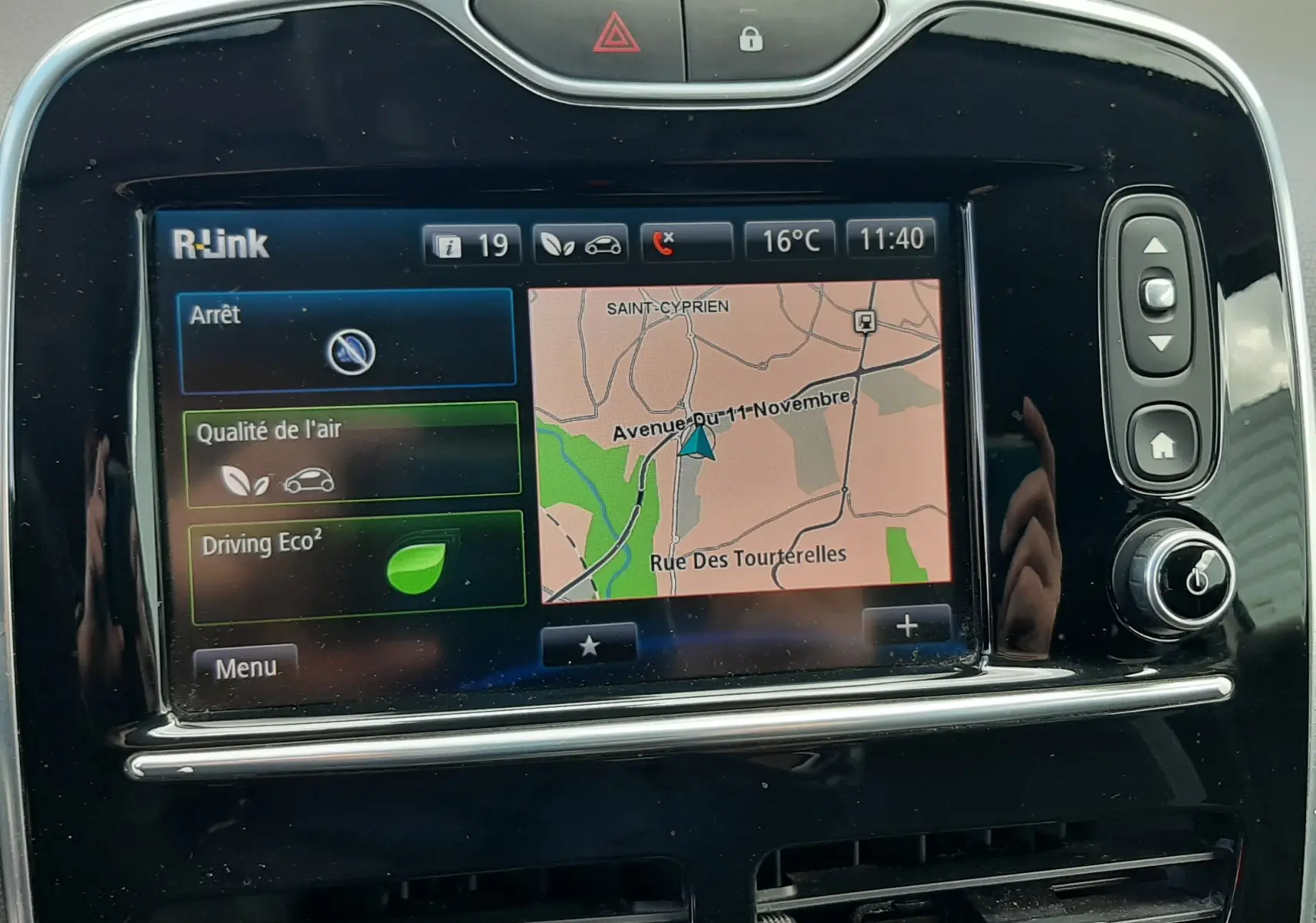 Écran tactile central R-Link de Renault Clio IV Estate beige, affichant navigation et options éco, vue de face intérieure.