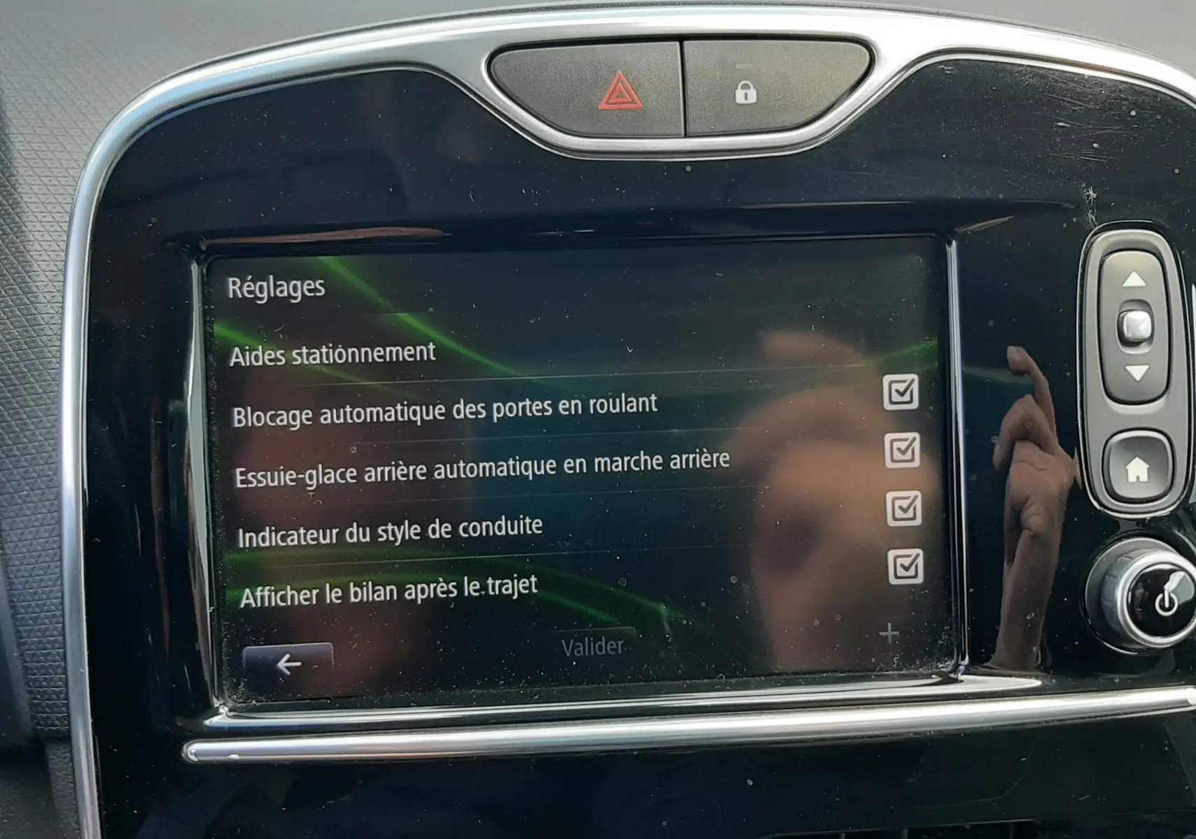 Écran tactile central de la Renault Clio IV Estate beige 2016 affichant les réglages d’aides à la conduite.