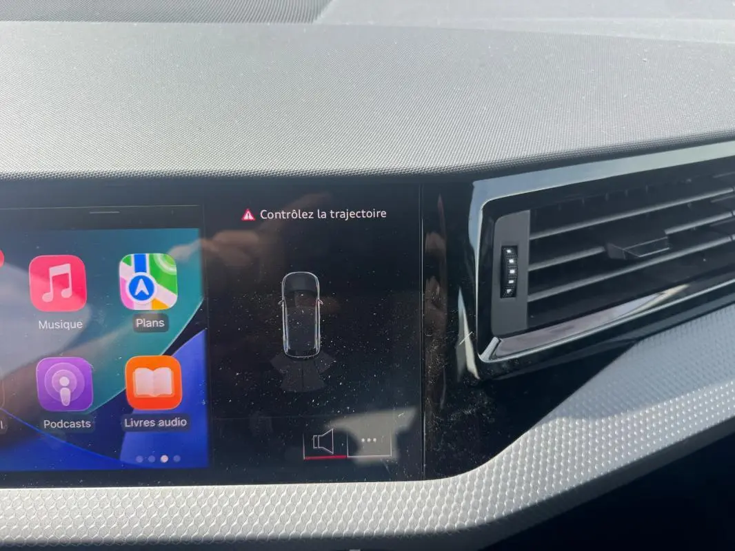 Vue rapprochée du tableau de bord gris de l'Audi A1 Sportback 2025 avec écran tactile et ventilation latérale.