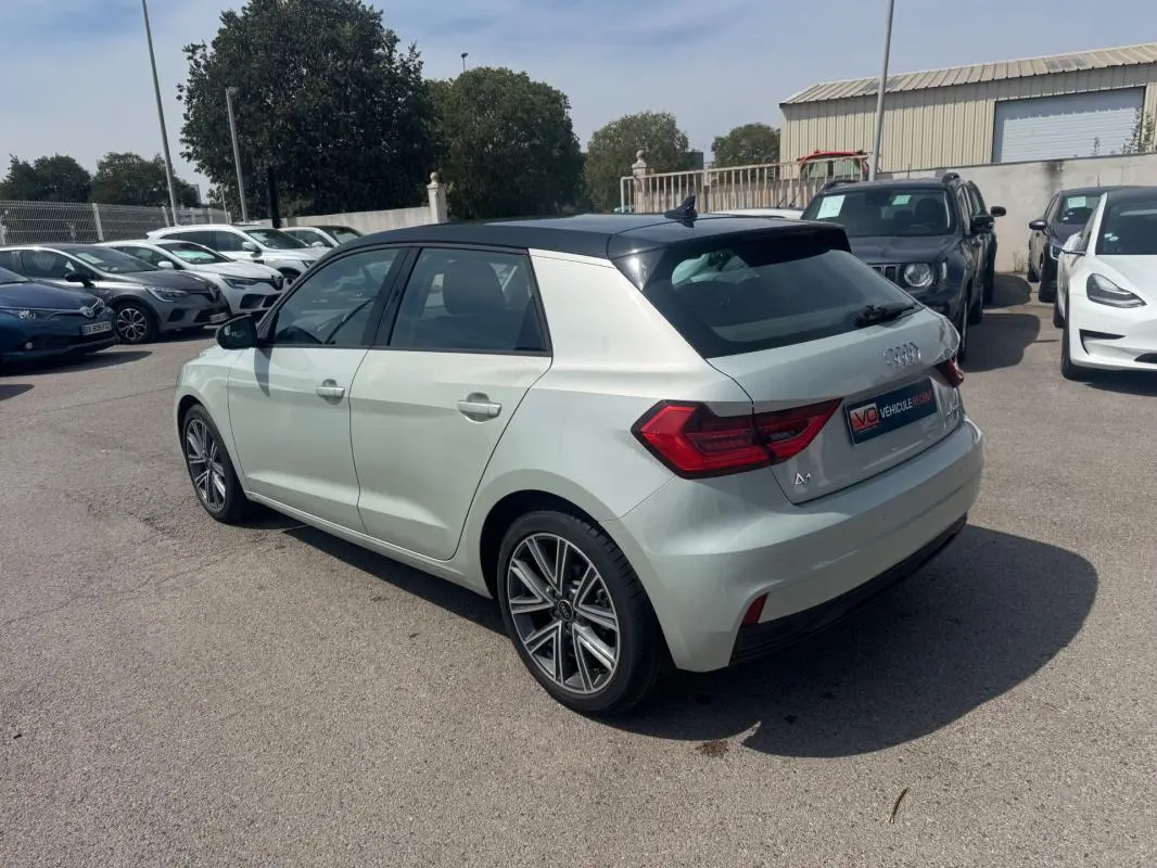 Audi A1 Sportback gris clair vue 3/4 arrière droit avec toit noir et jantes alliage distinctives.