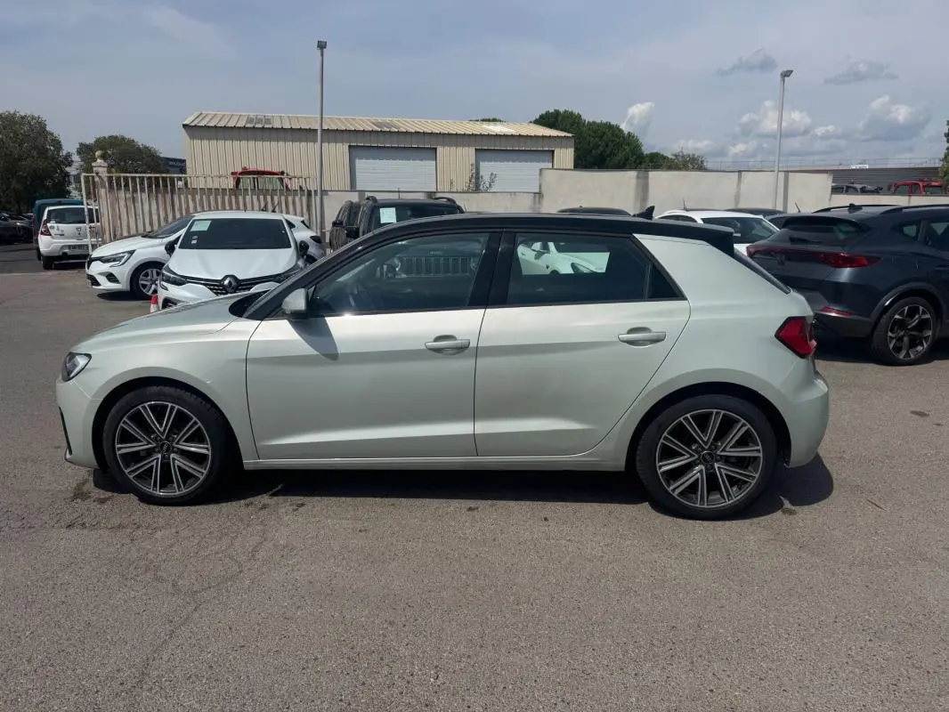 Audi A1 Sportback gris vue de profil côté gauche, avec toit noir et jantes alliage distinctives.