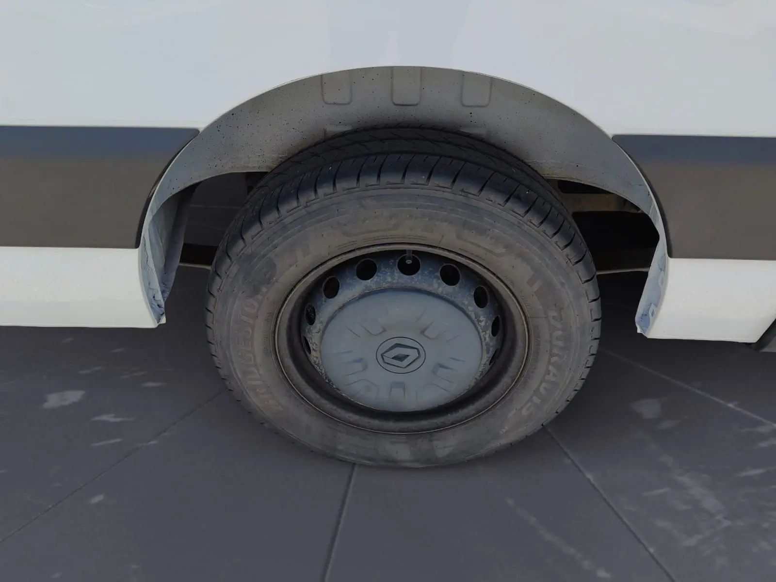 Gros plan sur la roue arrière droite d’un Renault Master blanc, avec jante acier et enjoliveur Renault visible.
