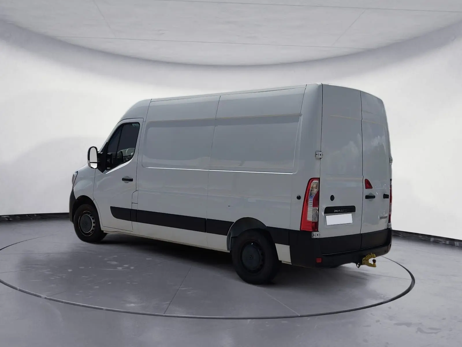 Renault Master blanc en vue 3/4 arrière droit, fourgon utilitaire avec hayon et attelage visible.